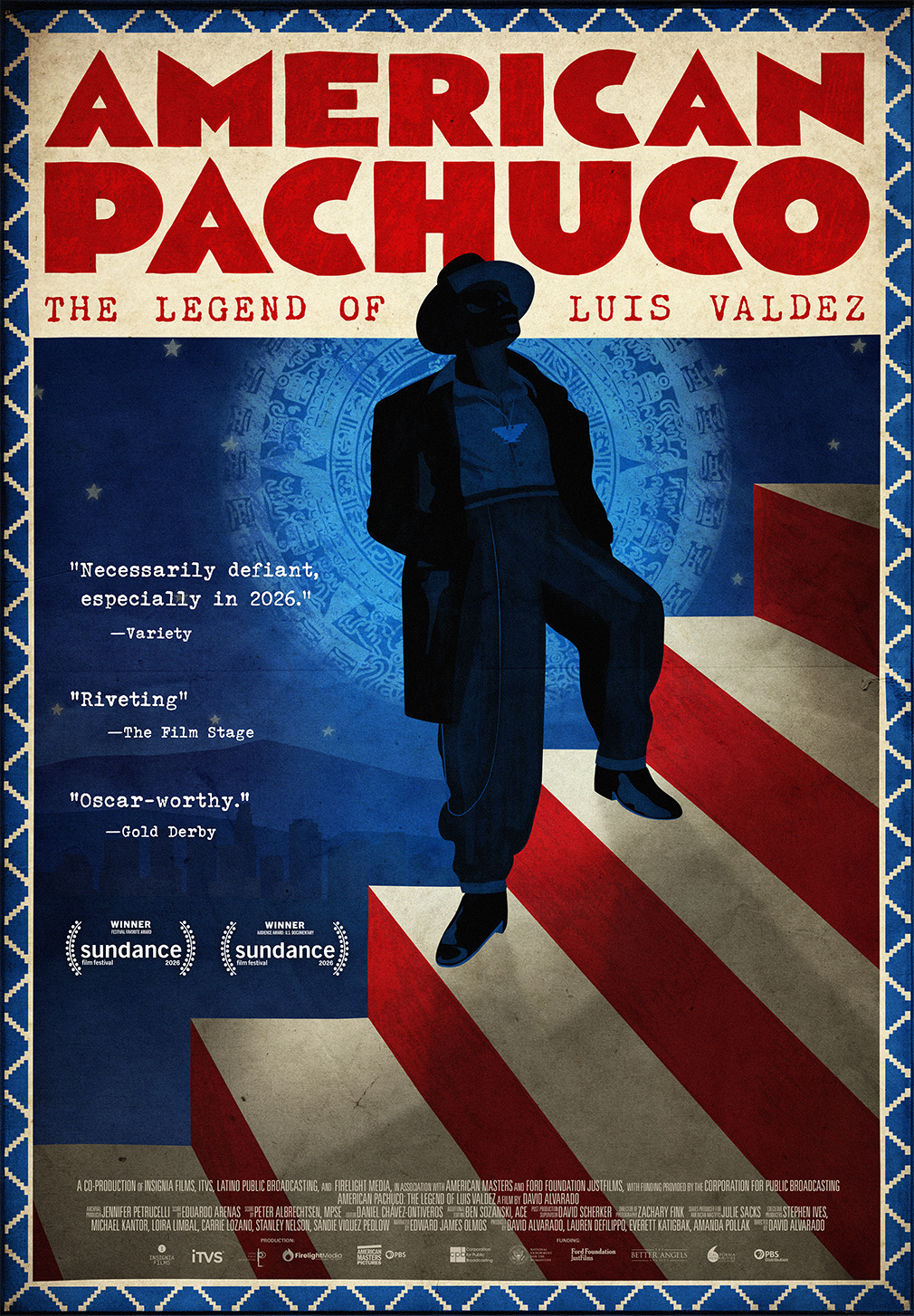 Movie poster for American Pachuco: The Legend of Luis Valdez. Illustration of a man in a zoot suit and wide-brimmed hat standing on red and white stripes that recede into the distance, his figure in deep blue silhouette against a night sky. A circular Aztec calendar design glows behind him. A woven blue and cream border frames the poster.