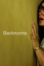 Movie poster for Backrooms. A woman with dark hair falling over her face presses her open hand and cheek against a yellow wall at the right edge of the frame, her mouth open. The rest of the poster is empty yellow wall. The title appears in gray letters center left near her hand.