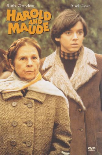 Movie poster for Harold and Maude. An older woman in a tweed coat and pale scarf stands in the foreground, and a young man in a shearling-collared coat and checked scarf stands close behind her. Both look past the camera with flat expressions. The background is a muted green outdoor setting. The title appears at the top in yellow letters.