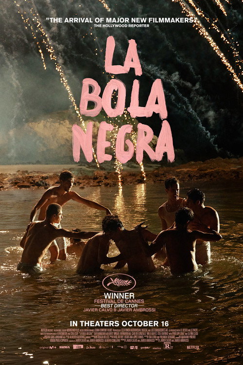 Movie poster for La Bola Negra. At night, a group of shirtless young men huddle close, waist-deep in dark water, while fireworks burst in the sky above. The title appears in large pink hand-drawn letters.