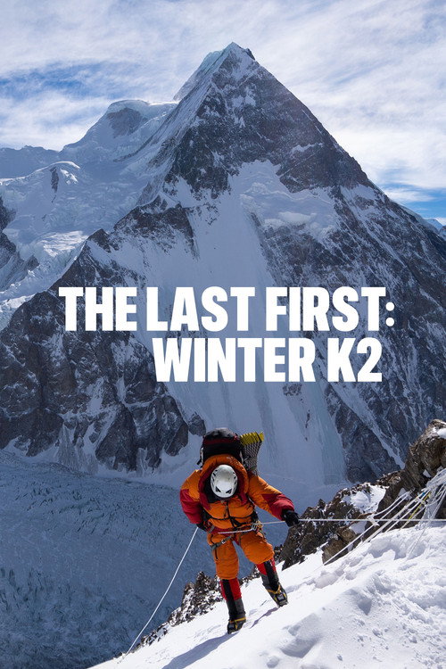 Movie poster for The Last First: Winter K2. A climber in an orange suit, goggles, and oxygen mask moves up a steep snow slope in the foreground, with a large snow-covered peak rising behind under a pale sky. The title appears across the center in white capitals.