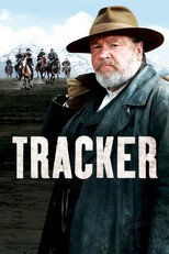 Movie poster for Tracker. A bearded older man in a wide brimmed hat and worn coat looks directly at the camera in the foreground. Behind him, a line of riders on horseback crosses an open plain below snow capped mountains. The title appears in white capitals across the lower third.