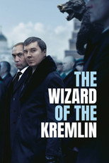 Movie poster for The Wizard of the Kremlin. Two men in dark overcoats stand side by side outdoors, one slightly behind the other, in front of a blurred red building and a crowd. Blurred figures in tall fur hats frame both edges. The title appears at right in white capitals on four lines.